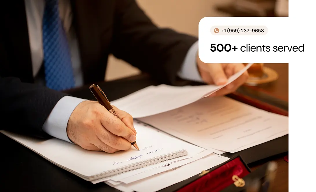 A person in a suit signs papers at a desk, symbolizing professionalism and reliability